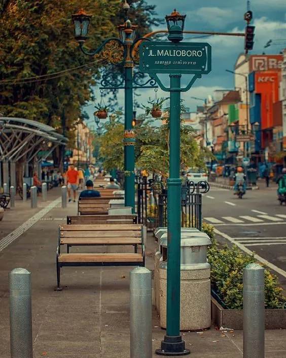 Papan nama Jalan Malioboro di atas bangku dan lampu hias di jalur pedestrian