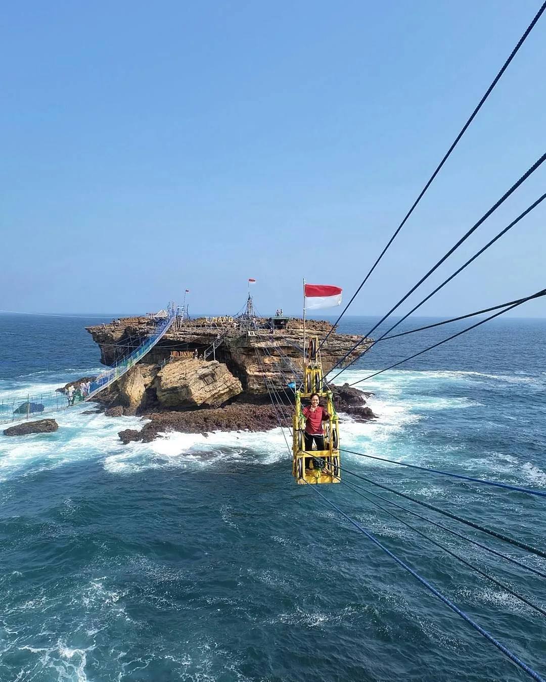 Pengunjung menyeberang ke pulau karang Pantai Timang dengan gondola tali di atas deburan ombak