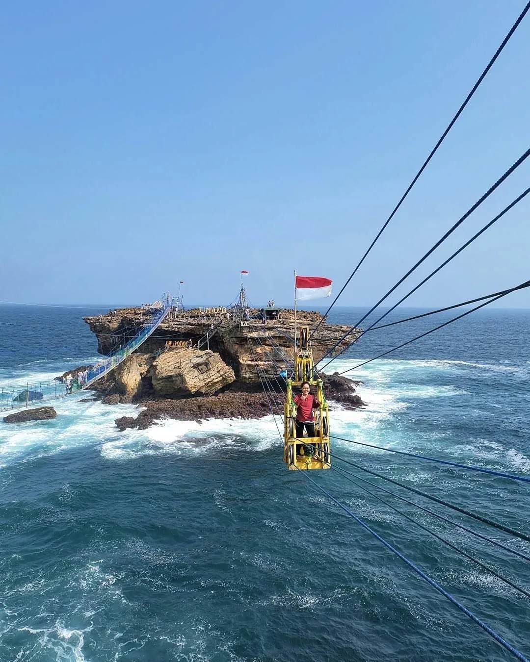 Pengunjung menyeberang ke pulau karang Pantai Timang dengan gondola tali di atas deburan ombak